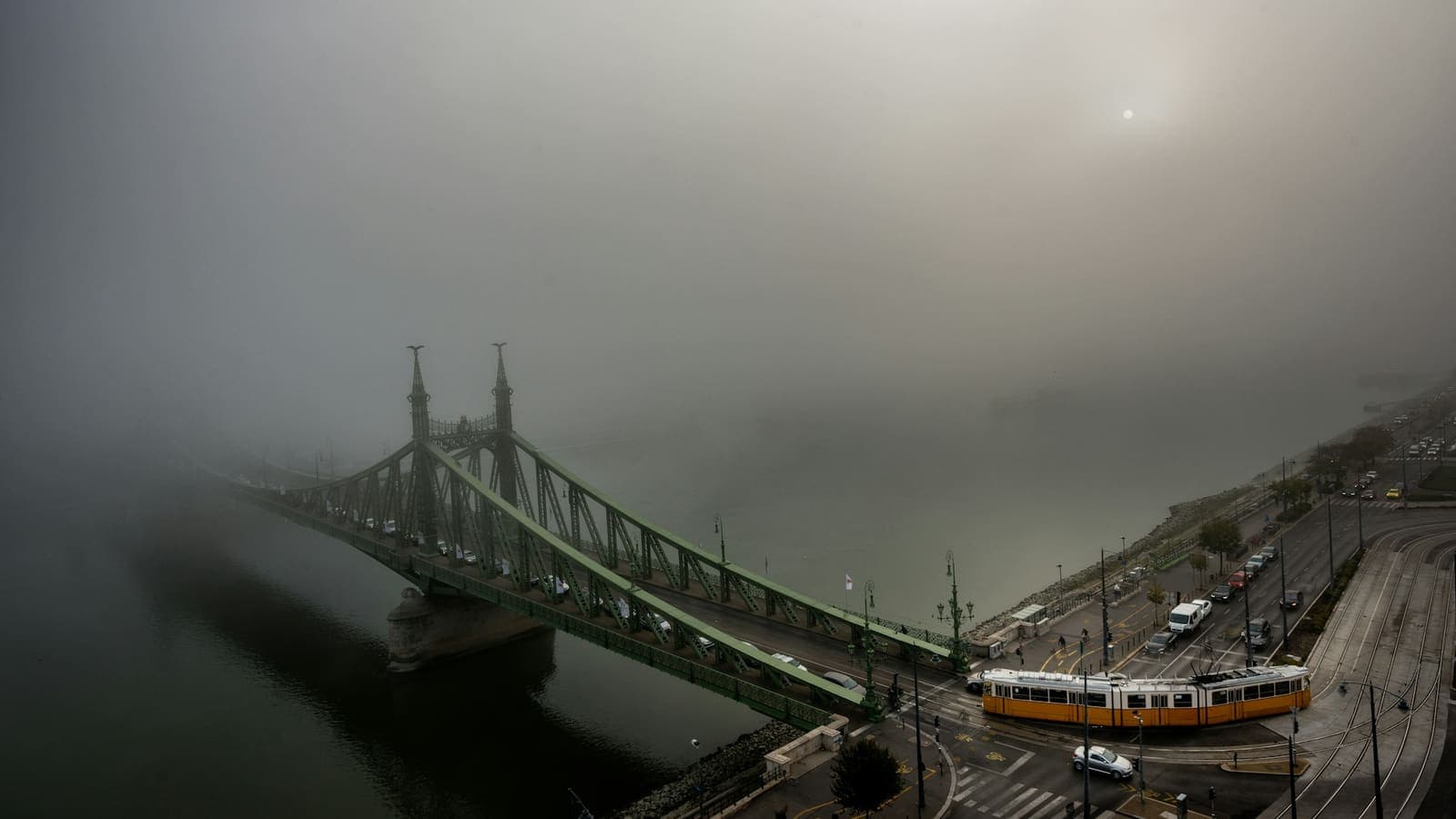 A train crossing a concrete bridge into low cloud — the transition from one side to the other