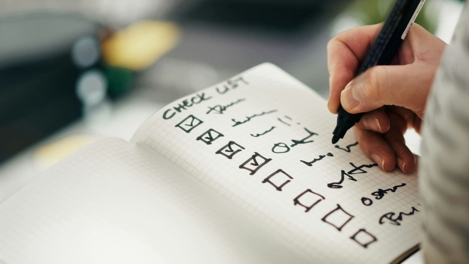 Someone ticking items off a printed checklist with a pen
