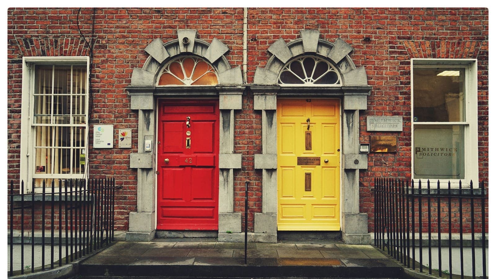 Two wooden doors side by side, one yellow and one red — two paths to choose between