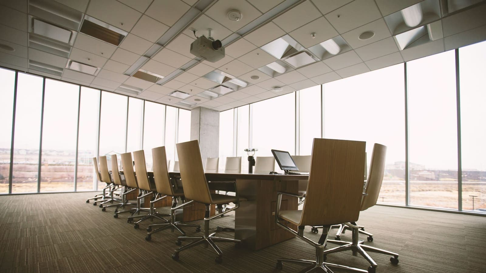 An empty oval conference table in a boardroom — where consulting engagements get decided