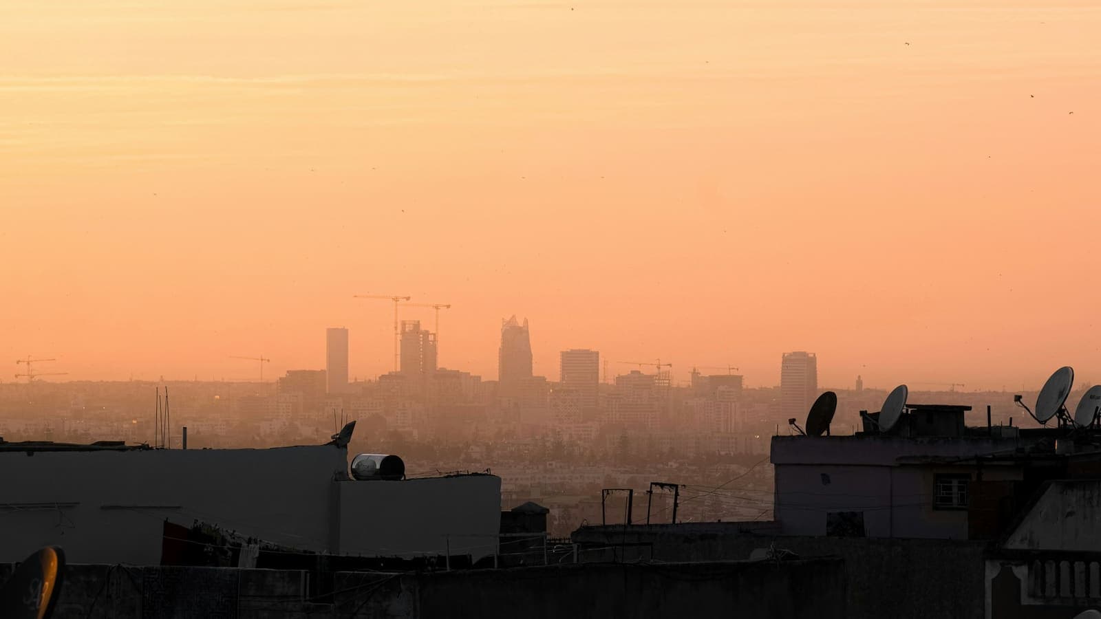 La skyline d'une ville vue depuis un toit au coucher du soleil