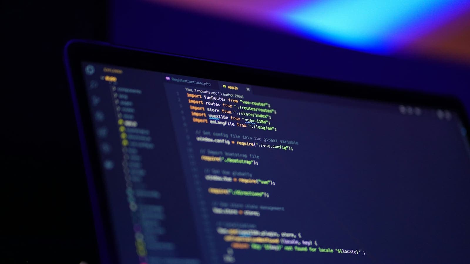 A laptop screen displaying colourful lines of code