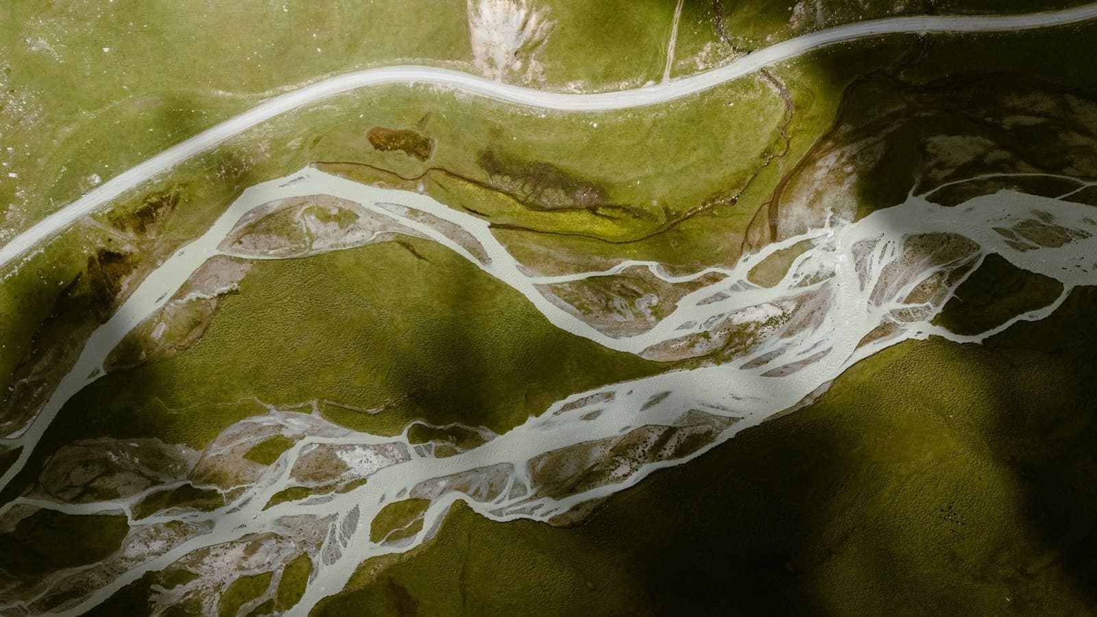 Aerial view of a river branching through green fields — several channels feeding one flow