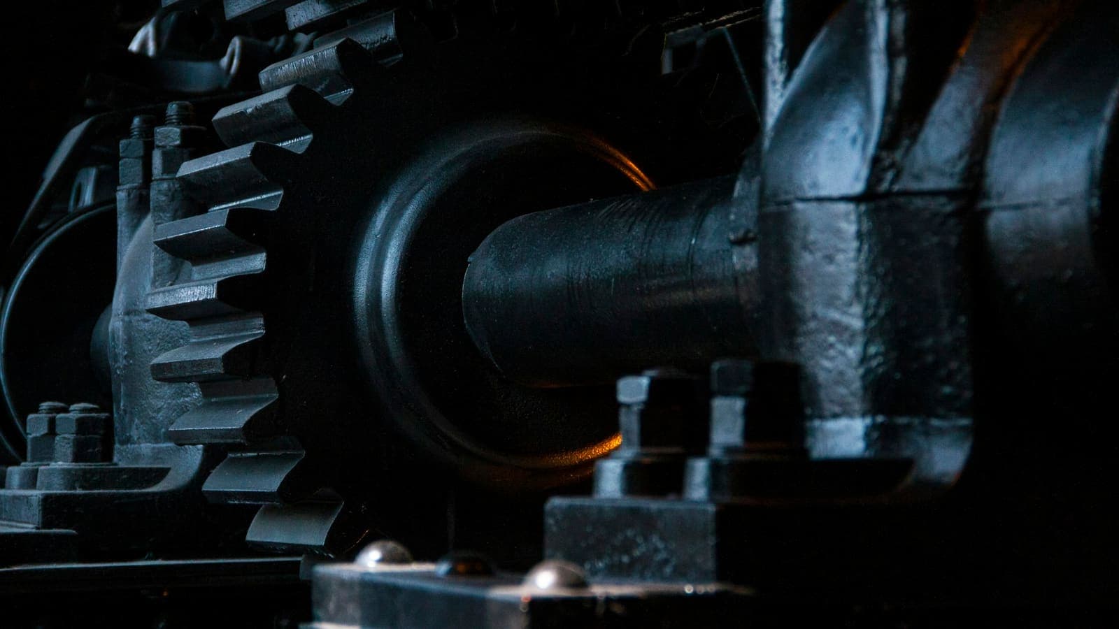 Close-up of interlocking black metal gears — parts that only work because they're connected
