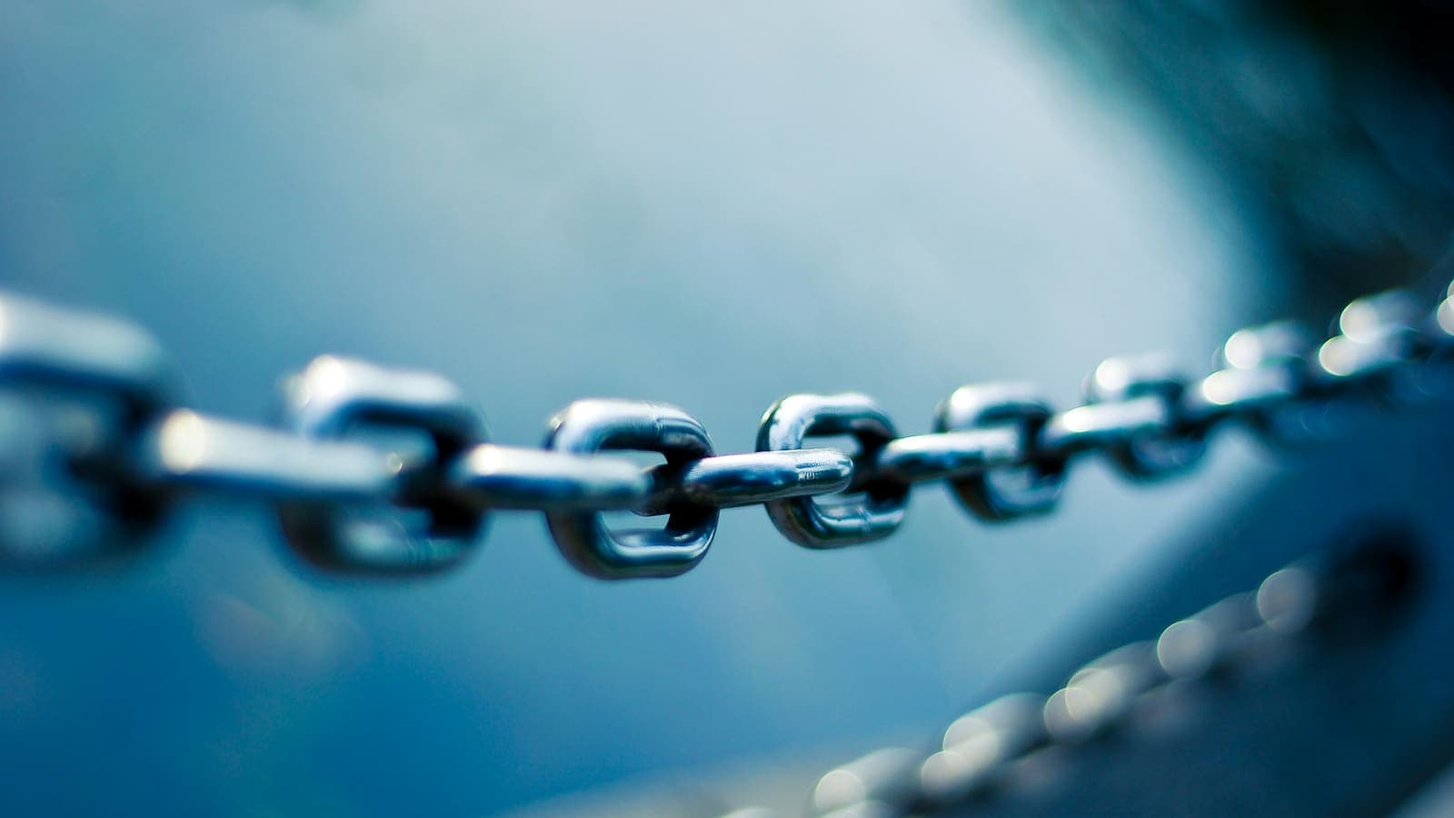 Gros plan sur une chaîne en acier inoxydable, un seul maillon net — là où la chaîne se rompt
