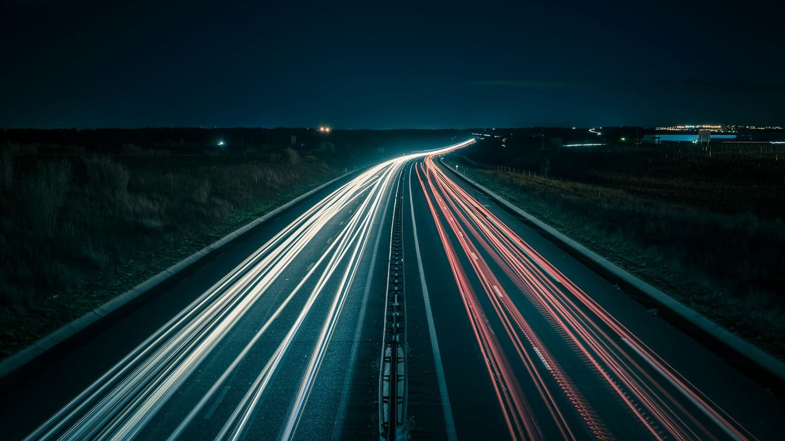 Traînées lumineuses en pose longue du trafic filant sur une autoroute la nuit