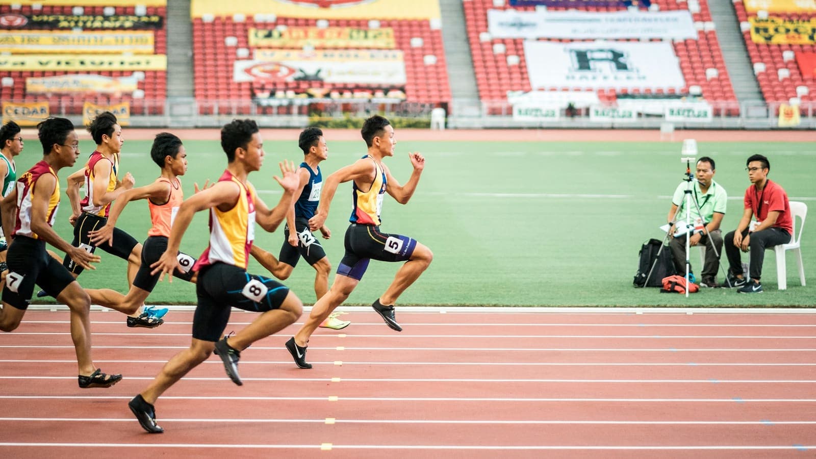A group of runners mid-race on an athletics track — a relay, not a solo sprint