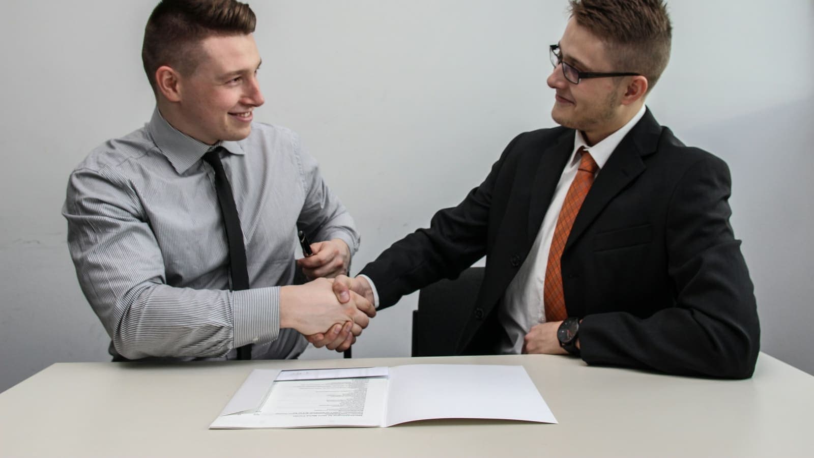 Two men shaking hands and smiling after a successful meeting