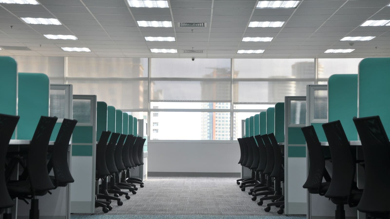Empty black office chairs at a row of cubicles — more desks don't fix a broken process