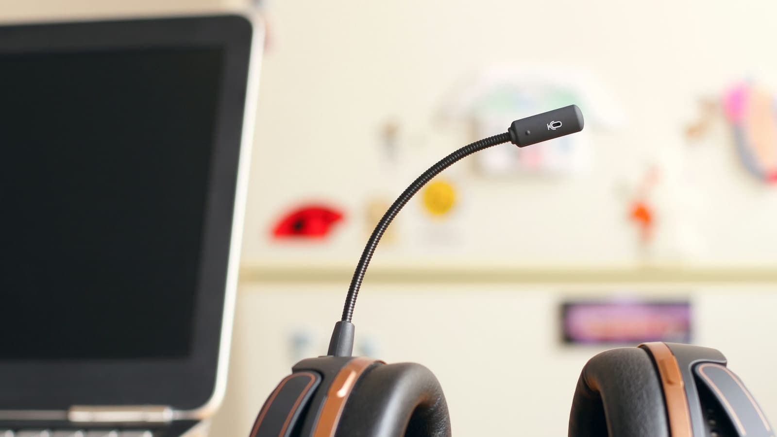 Un casque-micro posé à côté d'un ordinateur portable sur un bureau