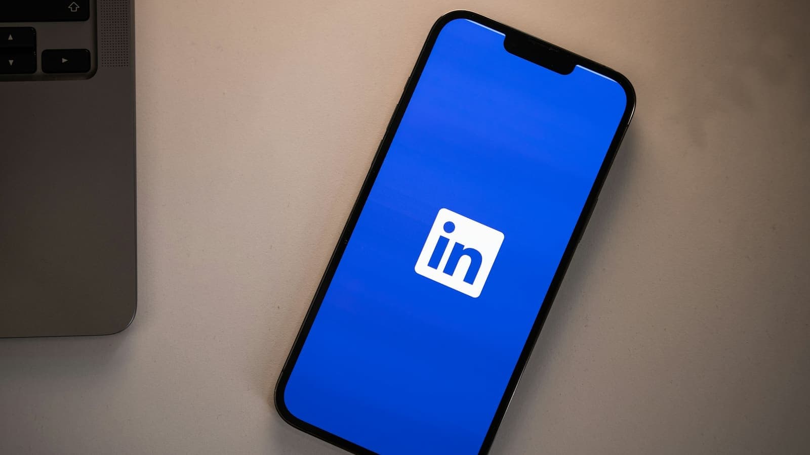 Un smartphone affichant le logo LinkedIn sur un écran bleu vif